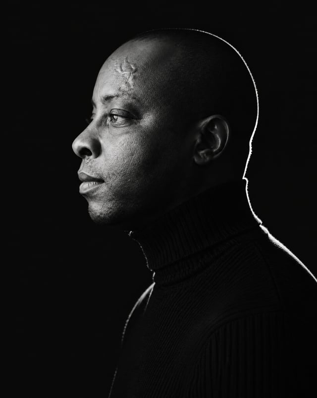A minimalist black and white cinematic portrait featuring one individual (male) in strict side profi