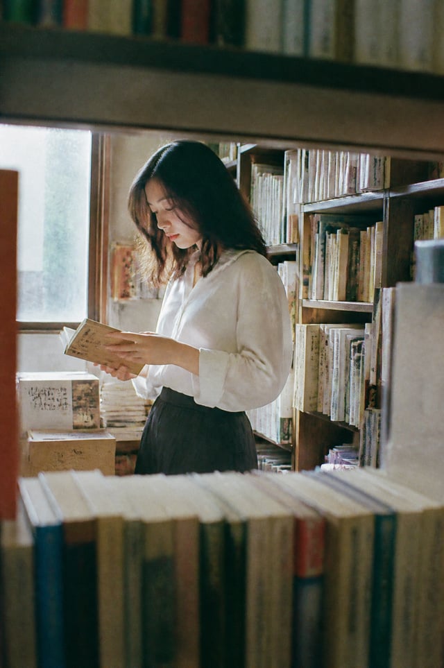 A beautiful Japanese woman browsing old books inside a tiny independent bookstore in Tokyo, oversize