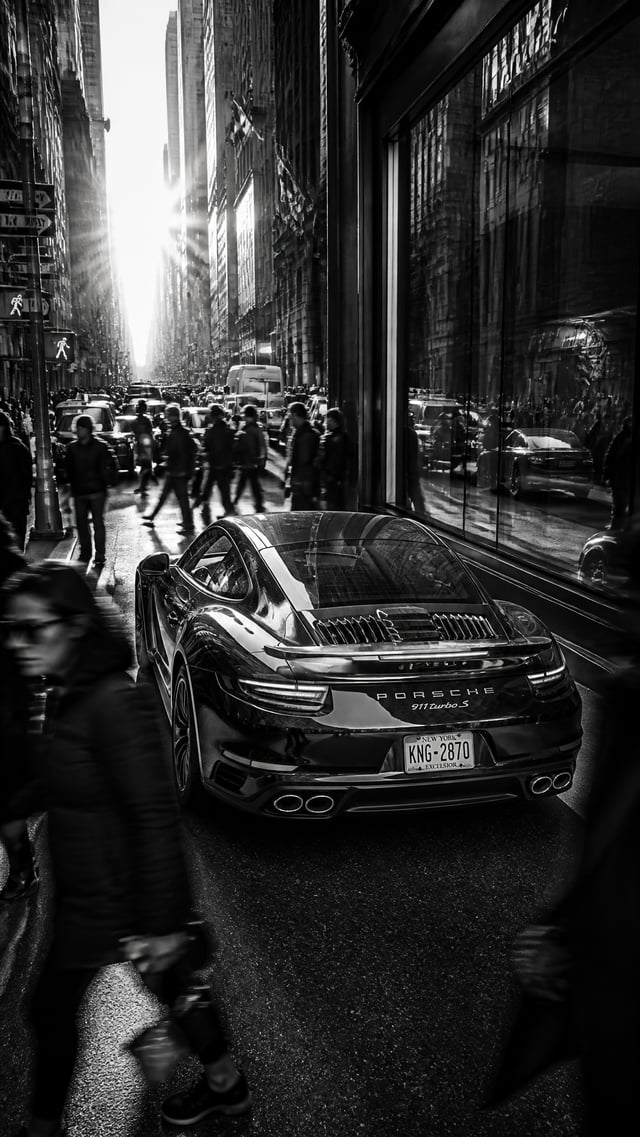 A stunning Porsche 911 parked confidently in the center of a bustling metropolitan street, surrounde