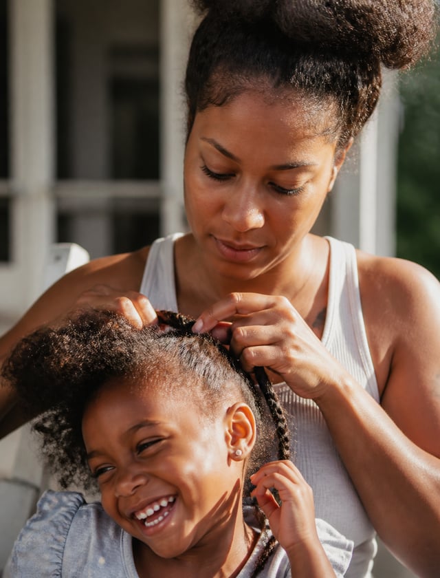 An ultra-realistic documentary portrait of a young mother braiding her daughter's hair on a sunlit p
