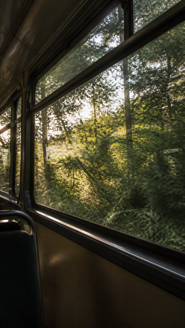 Ultra-realistic emotional fine-art film photograph taken from inside an empty vintage train or bus, 