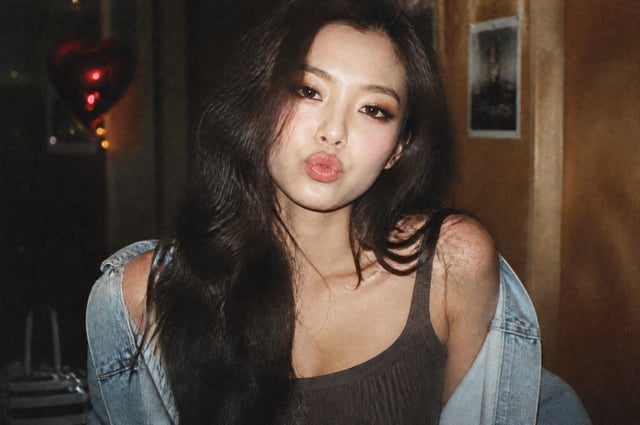 人物的姿势和表情:姿势和构图：以正面为中心的中等特写/拆分（Bust shot）构图，密集地记录了人物的脸部和肩膀线条。姿势：将牛仔外套宽松地披在肩下，自然地露出锁骨和颈部线条，上身向镜头微微倾斜。表