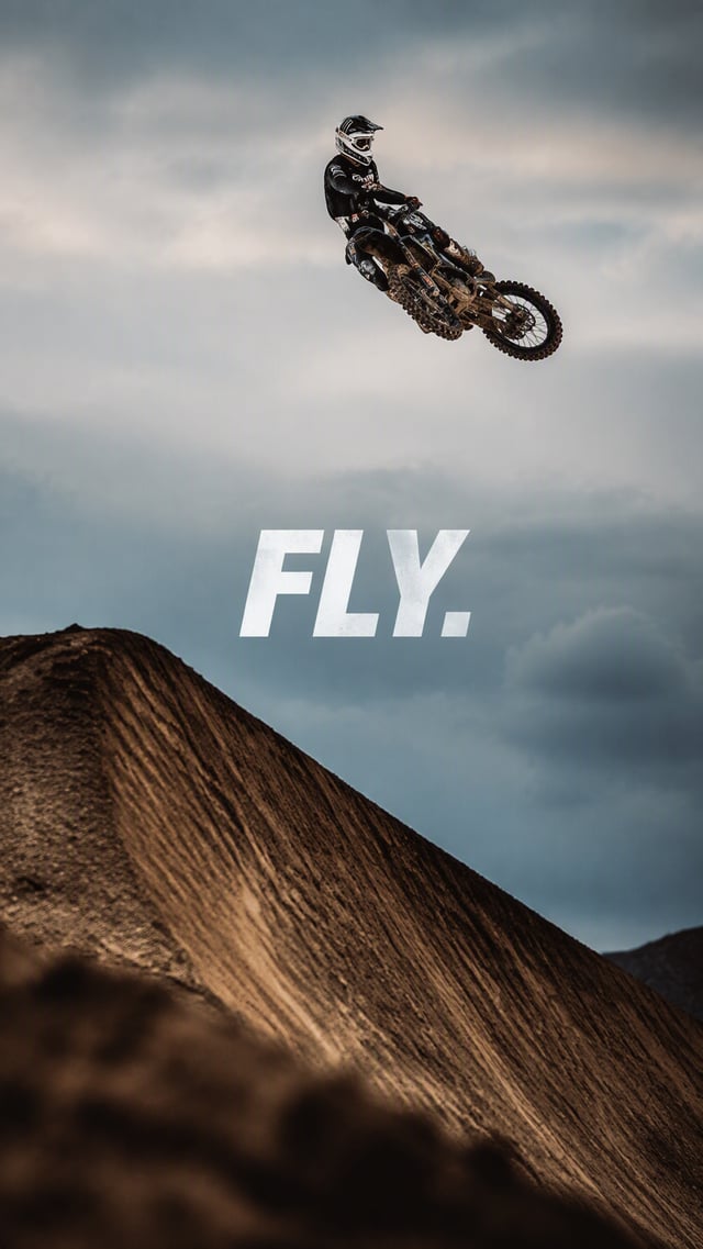 Create a premium 9:16 action-sports editorial.Main Subject: Young male motocross rider suspended hig