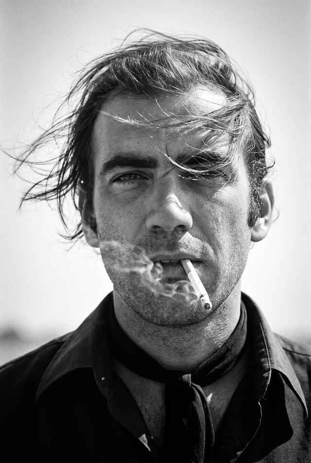 Create a 1970s black-and-white close-up portrait in a windswept outdoor setting, black and white noi