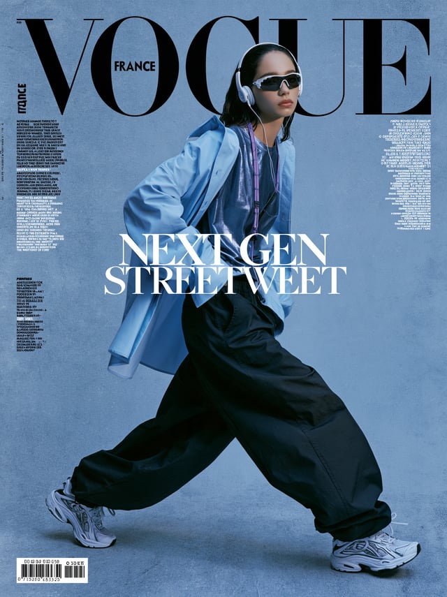 a textured, blue toned magazine cover featuring a model in a dynamic walking pose. the model is dres