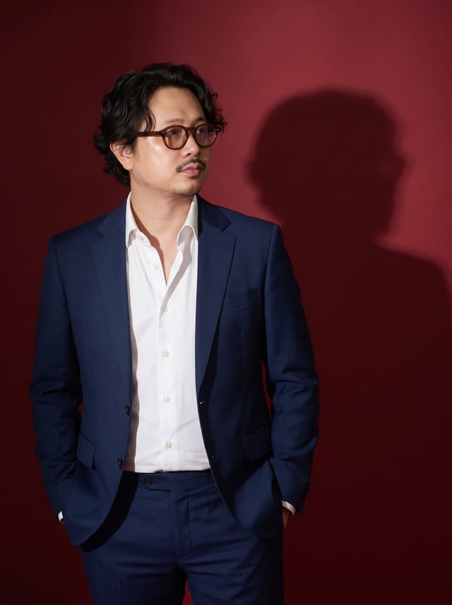 A fine art editorial portrait of the subject Wearing a perfectly tailored slim-fit navy blue suit an