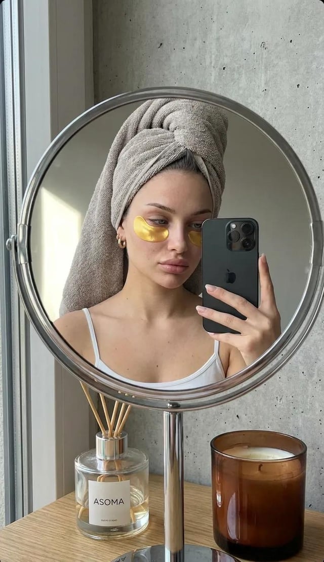 A highly realistic mirror selfie of a young woman taken through the reflection of a round tabletop m