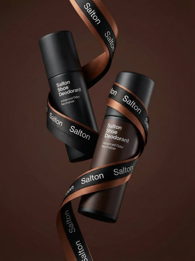 A product photo in a premium advertising style. Two tall matte bottles of Salton Shoe Deodorant levi