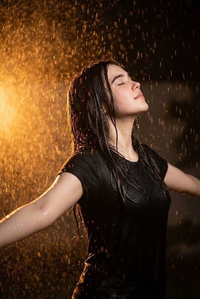 Ultra realistic cinematic portrait of a 32-year-old young woman standing in heavy rain at night, arm