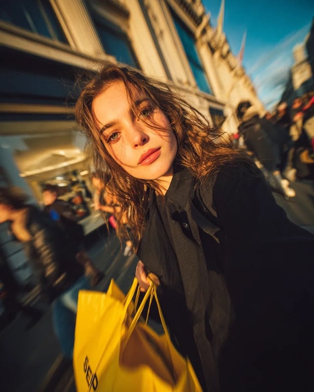 Cinematic street portrait of a young woman walking through a busy shopping street at golden hour, ho