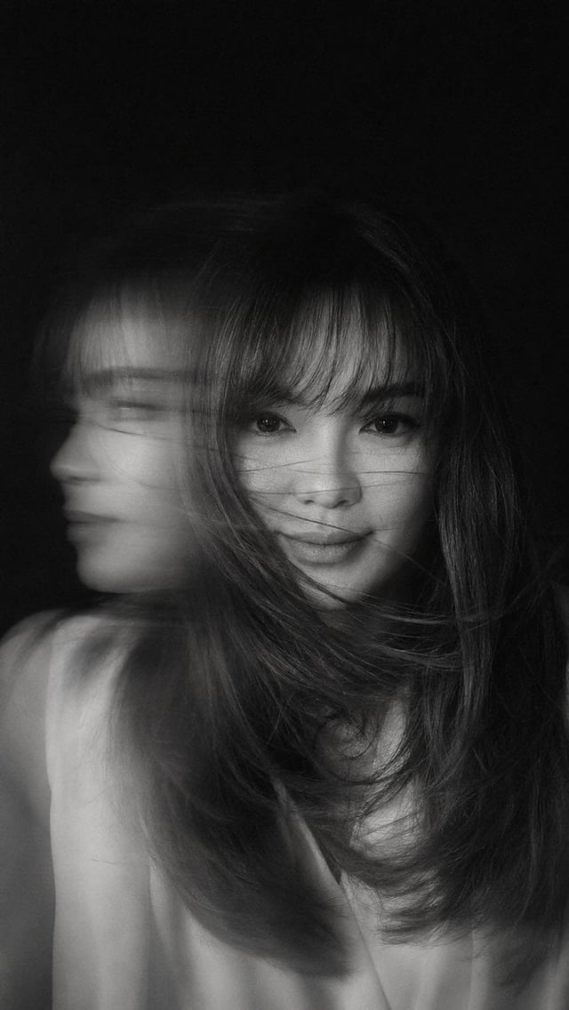 A hyper-realistic, cinematic black-and-white portrait of a woman caught in mid-motion, her face part