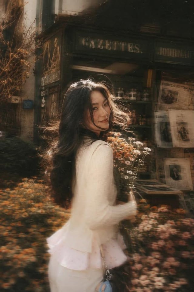 A beautiful young woman with long dark flowing hair holding a bouquet of soft pink roses, turning ba