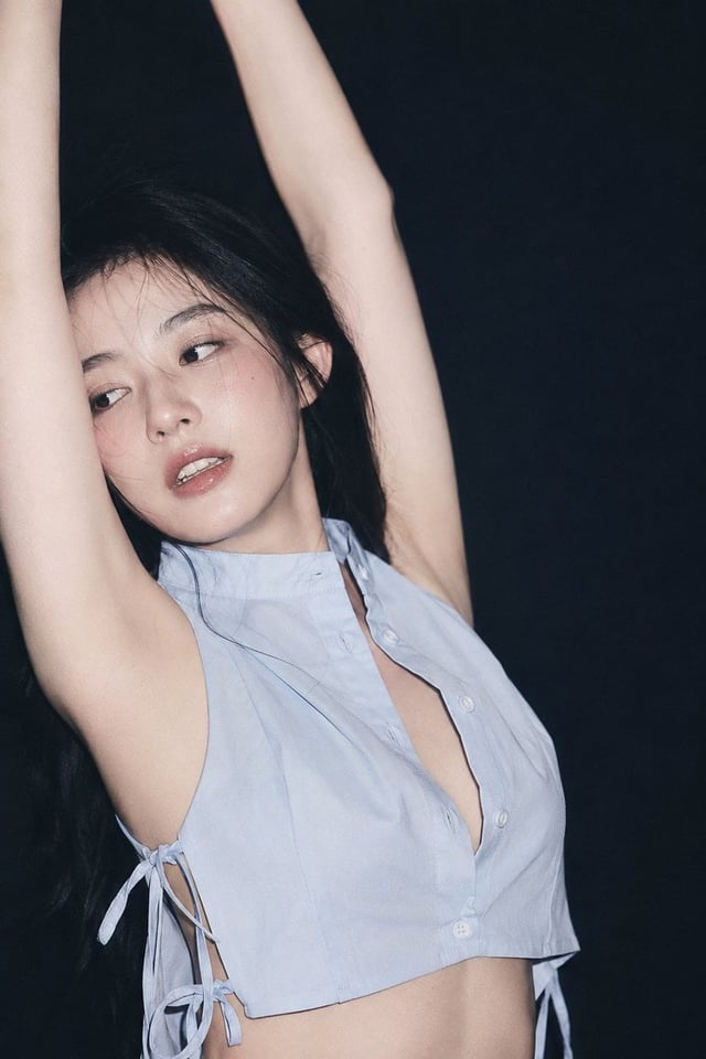 2:3，ccd直闪 90s 胶片杂志写真气质 近景半身裁切，人物占画面左中部与中央，人物2/3侧面视角，角色双臂上举形成纵深向框架（抬手拉伸），微侧头头部偏左，靠近左手臂。眼神湿润而游离，不直视镜头；
