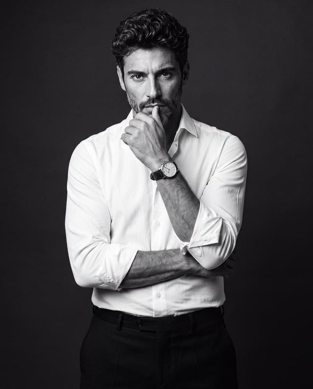 Create a premium black-and-white studio portrait of the uploaded man, preserving his recognizable fa