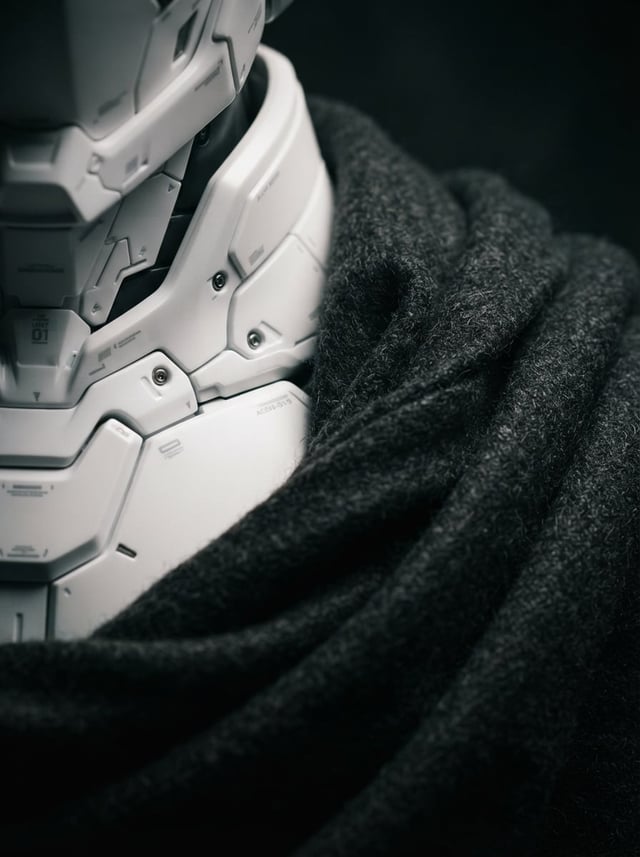 An elegant, minimal macro photograph showcasing the fusion of a pristine white polymer mecha-suit co