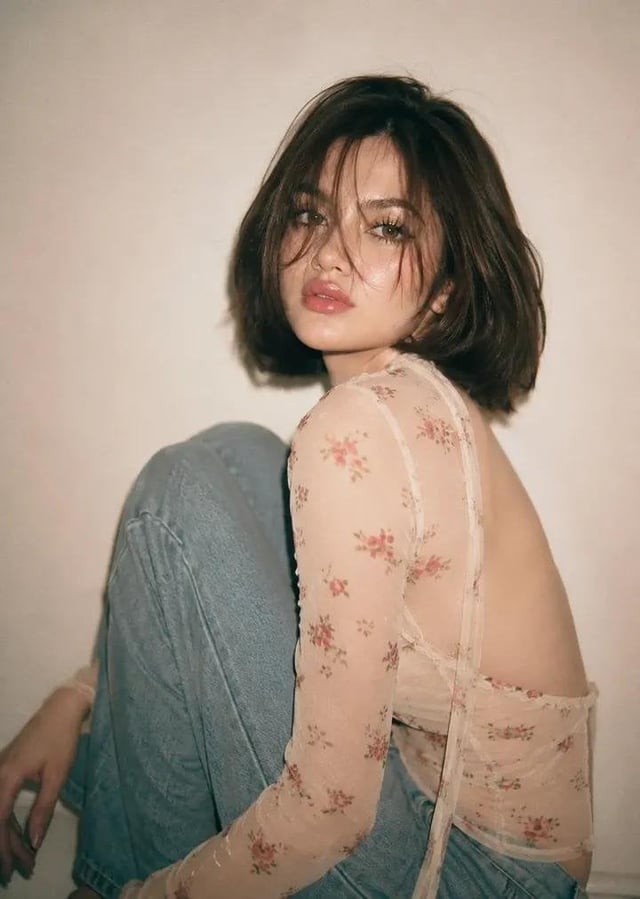 Create a reference photo of a beautiful young woman with fair skin, soft facial features, a defined 