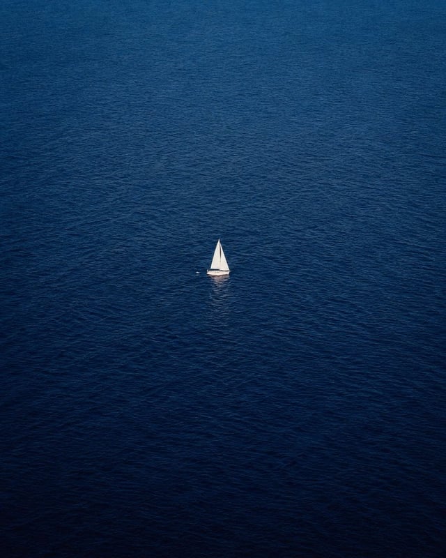 Prompt 1: An ultra-minimalist aerial drone photograph of a vast deep-blue ocean stretching endlessly