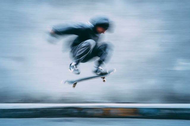 A blurred silhouette of a [Subject] in motion, wearing a [Color] sports kit, captured with a slow sh