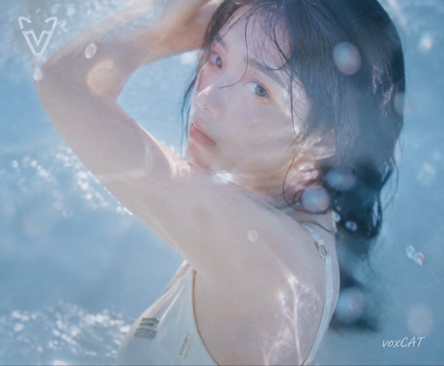 日系夏日水感写真，一位年轻女性角色，清透少女气质，湿润黑色长发，自然妆容，穿浅色简约泳装。
