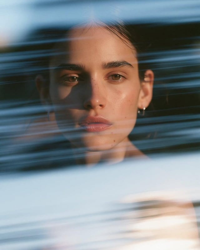 Ultra-realistic cinematic close-up portrait of a beautiful young woman with sleek dark hair pulled i