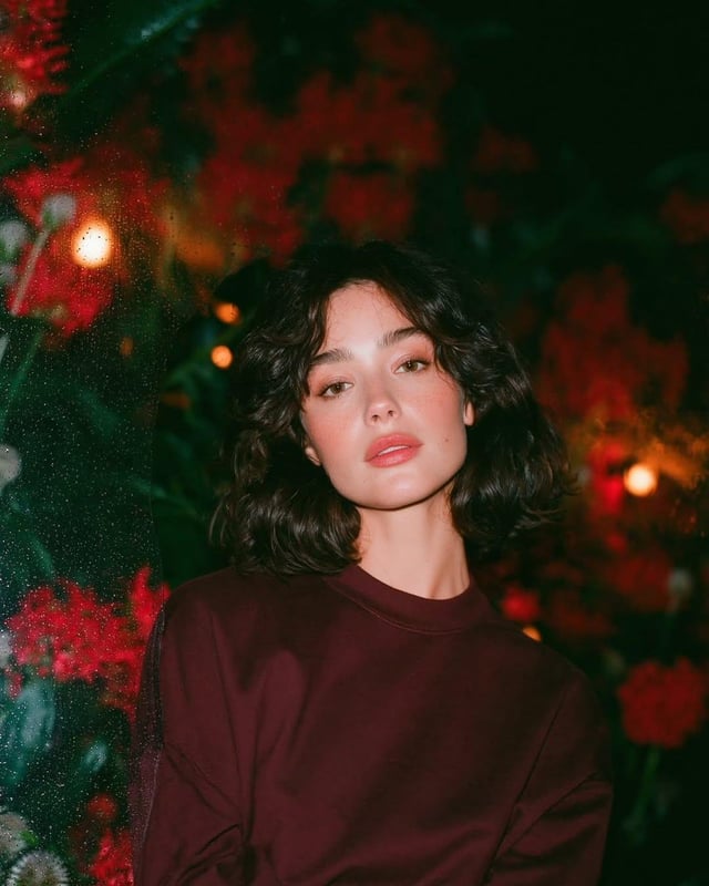 Dreamy cinematic nighttime portrait of a beautiful young woman with short wavy dark hair and glowing