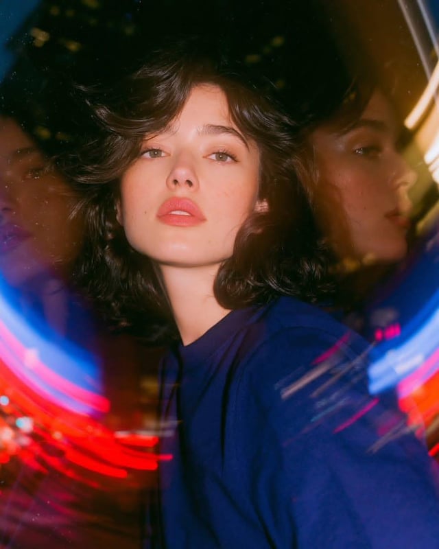 Photorealistic experimental cinematic portrait inside a large rotating glass entrance at night. One 