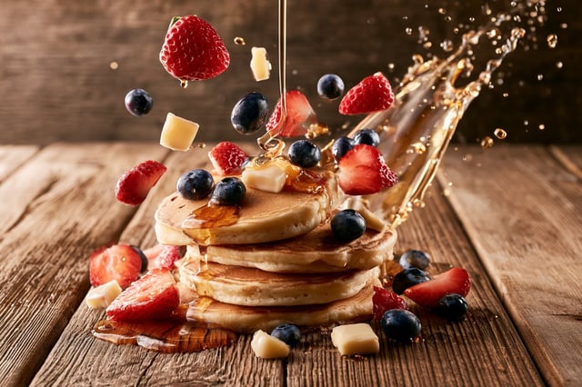 Premium commercial food advertising photograph of [Main Dish] resting naturally on a rustic wooden t