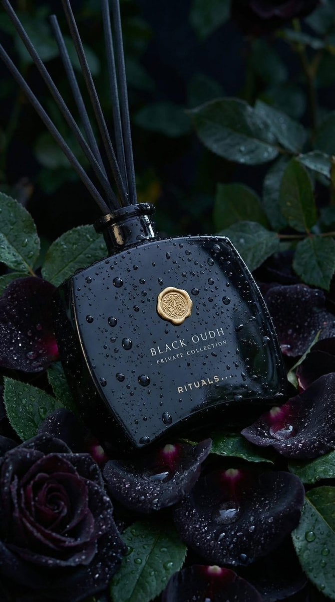 Ultra-realistic luxury product photography of a black glass reed diffuser bottle labeled “BLACK OUDH – Private Collec...